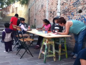 Katie Clancy making art with children at 11/2012 callejón fiesta.